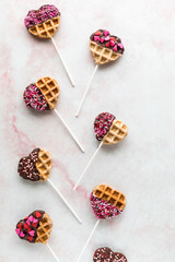 Mini Valentine decorated waffle pops, against a light background.