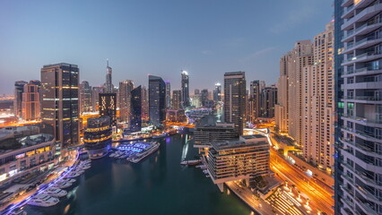 Fototapeta na wymiar Aerial view to Dubai marina skyscrapers around canal with floating boats night to day timelapse