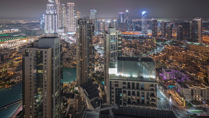 Fototapeta na wymiar Panorama showing aerial view of a big futuristic city night timelapse. Business bay and Downtown