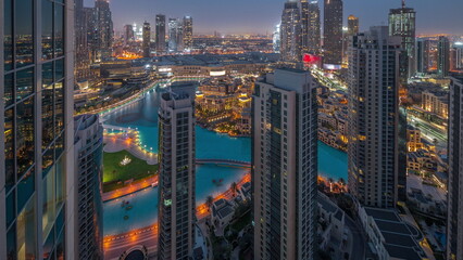Fototapeta na wymiar Dubai downtown with fountains and modern futuristic architecture aerial night to day timelapse