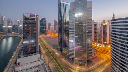 Obraz premium Cityscape of skyscrapers in Dubai Business Bay with water canal aerial night to day timelapse
