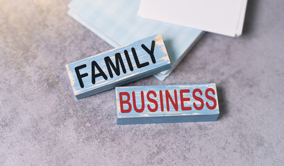 FAMILY BUSINESS text on a wooden block with chart and notebook, business concept