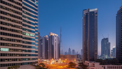 Plakat Aerial panoramic view to Dubai downtown and difc skyscrapers night to day timelapse.