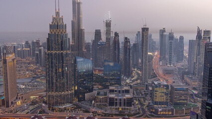 Obraz premium Aerial view of tallest towers in Dubai Downtown skyline and highway day to night timelapse.