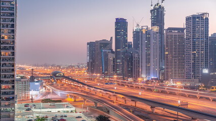 Naklejka na ściany i meble Dubai Marina skyscrapers and Sheikh Zayed road with metro railway aerial day to night timelapse, United Arab Emirates