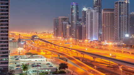 Obraz na płótnie Canvas Dubai Marina skyscrapers and Sheikh Zayed road with metro railway aerial night to day timelapse, United Arab Emirates