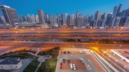 Dubai Marina skyscrapers and Sheikh Zayed road with metro railway aerial night to day timelapse, United Arab Emirates