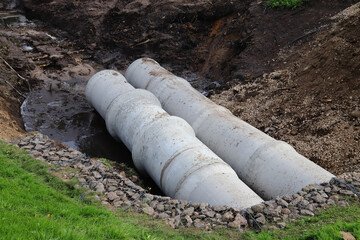 laying drainage concrete pipes into the ground