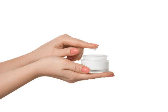 Thick hand cream on a woman's palm, 2nd hand finger takes a drop of cream. Groomed hands,  pink nail polish.