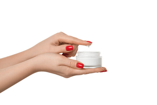 Thick hand cream on a woman's palm, 2nd hand finger takes a drop of cream. Groomed hands, red nail polish.