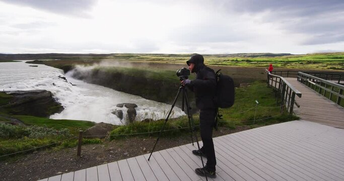 Iceland Photographer at Gullfoss Waterfall on Iceland in Icelandic nature. Gullfoss aka Golden Falls is a famous tourist attraction and landmark on Icelands Golden Circle.