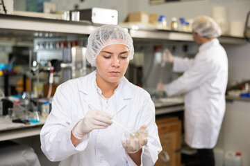 Portrait of young woman lab technician working in research laboratory, conducting experiment