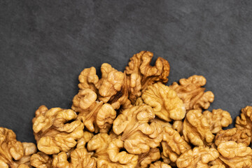 Walnuts. Walnut kernels on dark black stone background. Top view, flat lay