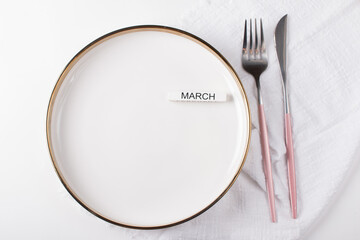 Festive table setting. The number 8 decorated with flowers on a white plate. Congratulations on the International Women's Day on March 8, a festive postcard banner