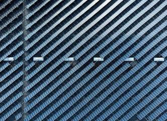 Top down view of diagonally stacked solar panels on a commercial building aerial photo