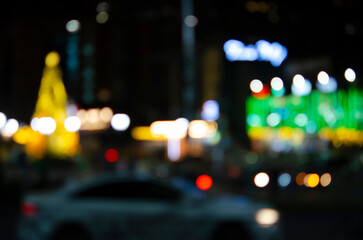 Night cityscape without focus. Blurred street background with illumination and bright lights. Neon illumination of the evening city.