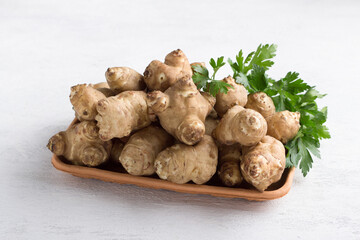 Fresh Jerusalem artichoke garnished with parsley on a light gray background. healthy diet veggi food