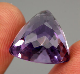 Natural gemstone purple amethyst on gray background