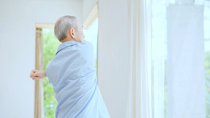 寝室でストレッチをする高齢者
