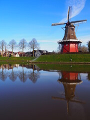 Windmill in dokkum sitting at the water. 