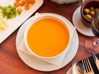 Gazpacho, cold Spanish soup, served in bowl on table in restaurant.