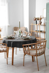 Beautiful table setting with burning candle in stylish room