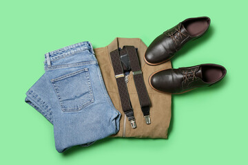 Male jeans, jacket, shoes and suspenders on green background
