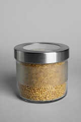 Glass jar with bulgur on white background