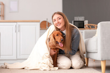 Young woman with red cocker spaniel and plaid in kitchen
