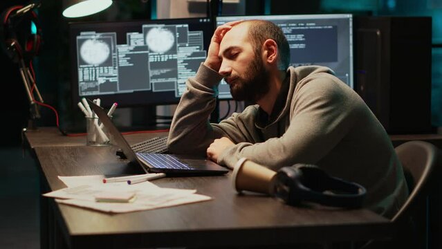 App IT engineer sleeping on desk and being drained, trying to work with artificial intelligence at night. Tired sleepy man yawning and falling asleep in office, using multiple monitors.