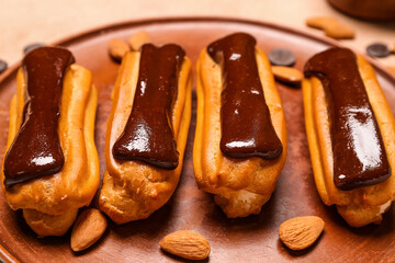 Plate with delicious chocolate eclairs, closeup