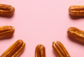 Composition with sweet eclairs on pink background