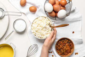 Female hand with ingredients for preparing cheese pie on white background