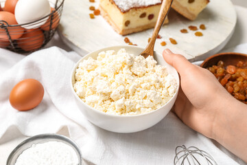 Female hand with ingredients for preparing cheese pie on white background
