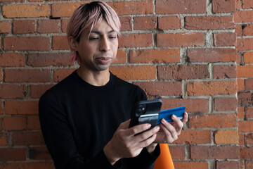 Fototapeta premium Non-binary person using their phone outside.