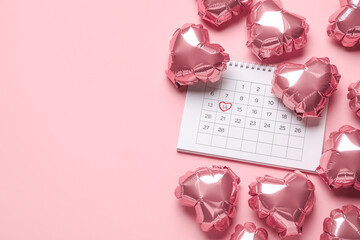 Calendar with marked date of Valentine's Day and balloons on pink background