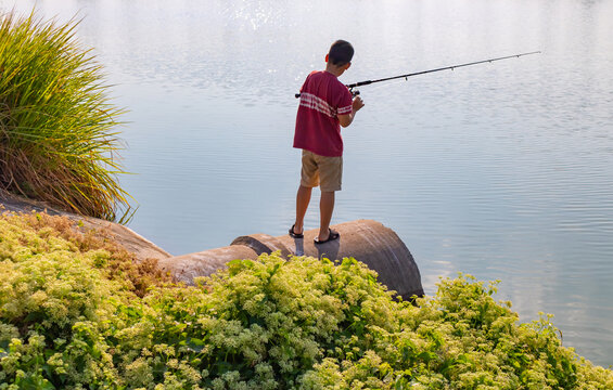 Boy is stand and fishing on culvert