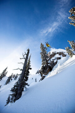 A male telemark skier front flips off a cliff in Montana.