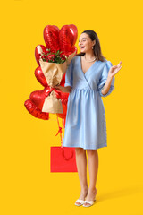 Beautiful woman with roses and balloons on yellow background. Valentine's Day celebration