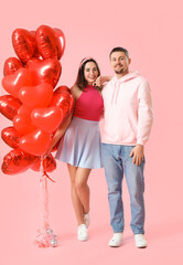 Happy couple in love with balloons on pink background. Valentine's Day celebration