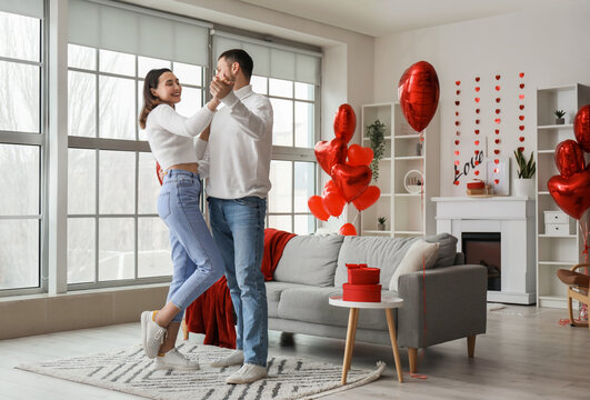 Happy couple in love dancing at home on Valentine's Day