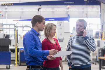 Business people showing document to mature businessman talking on phone