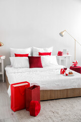 Interior of bedroom decorated for Valentine's Day with engagement ring and gifts