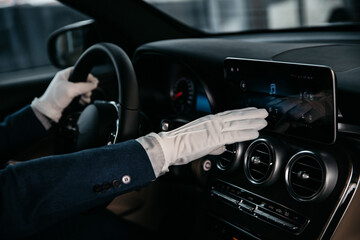 Obraz premium manager in a white glove demonstrates the functions of a luxury car