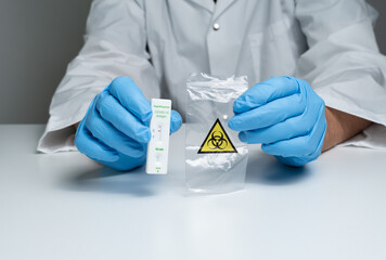 Nurse display of negative Covid-19 antigen rapid test near biohazard waste plastic bag. Rapid antigen test for detection of SARS-CoV-2. Negative test.