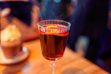 Christmas mulled wine or gluhwein with spices with hot steam, traditional drink on winter holiday, selective focus