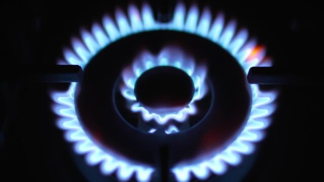 Stove burner ignites into blue cooking flame. Top shot Slide Closeup. Turn off or on blue color flame