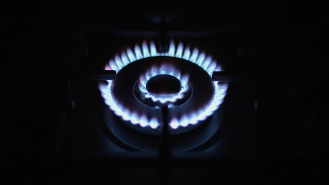 Slow motion shot ignites gas stove,  Domestic kitchen gas stove burning in blue flames