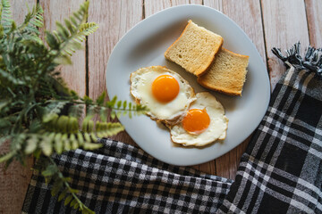 A top down and side view of eggs on the plate with toast bread on the side for breakfast clean meal healthy food 