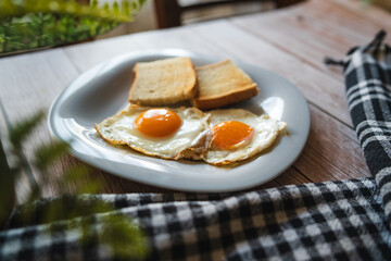 A top down and side view of eggs on the plate with toast bread on the side for breakfast clean meal healthy food 